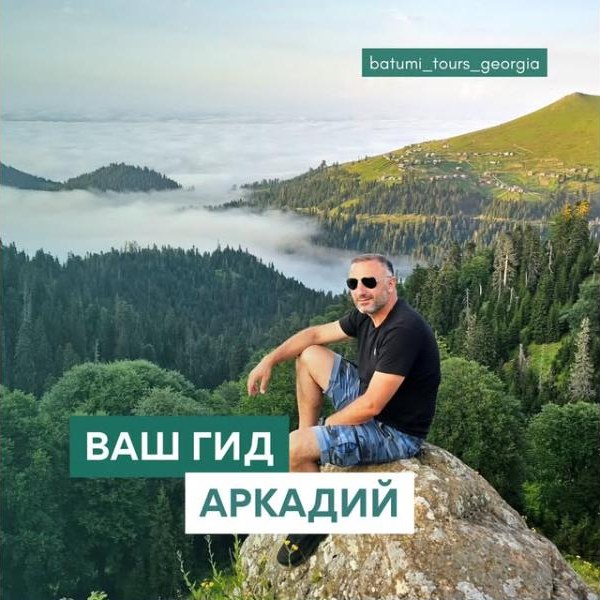 Arkadi sitting on a rock above the clouds, with the caption “Your guide Arkadi”