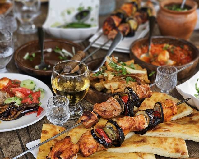 A table with barbecue, khachapuri and wine