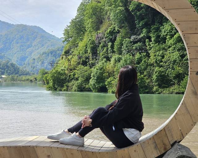 Wooden crescent-moon swing above a river