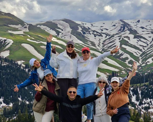 Tour guests against Bakhmaro’s snow-striped mountains