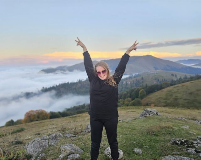 A guest with raised arms above the clouds