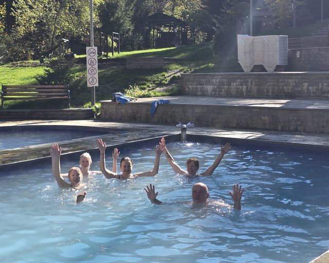 Guests splashing in an outdoor pool in the sun