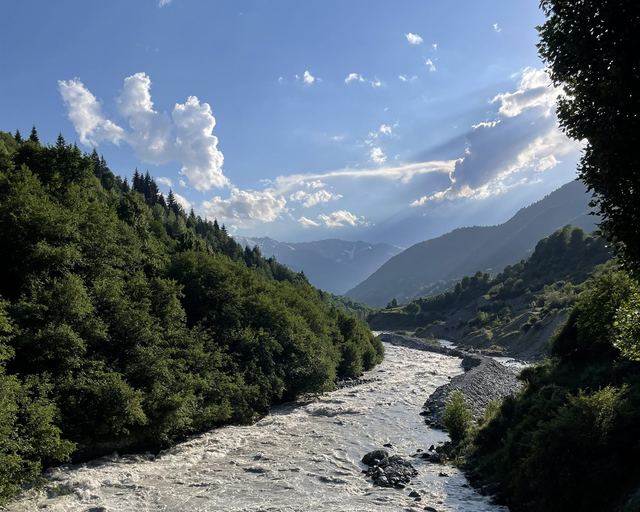 A mountain river in a wooded gorge beneath the clouds