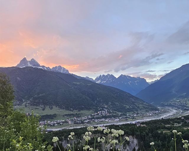A river valley and peaks in sunset clouds