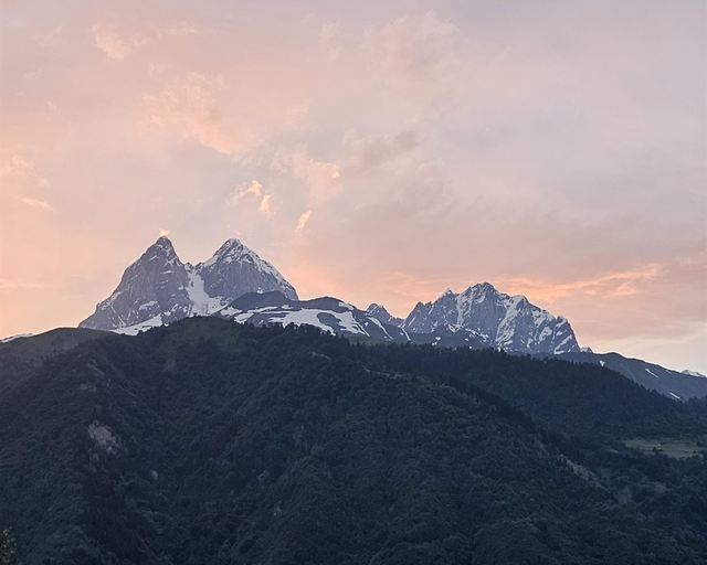 Snowy peaks against a pink sunset sky